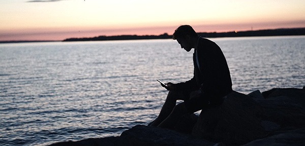 Man reading on his phone in silhouette